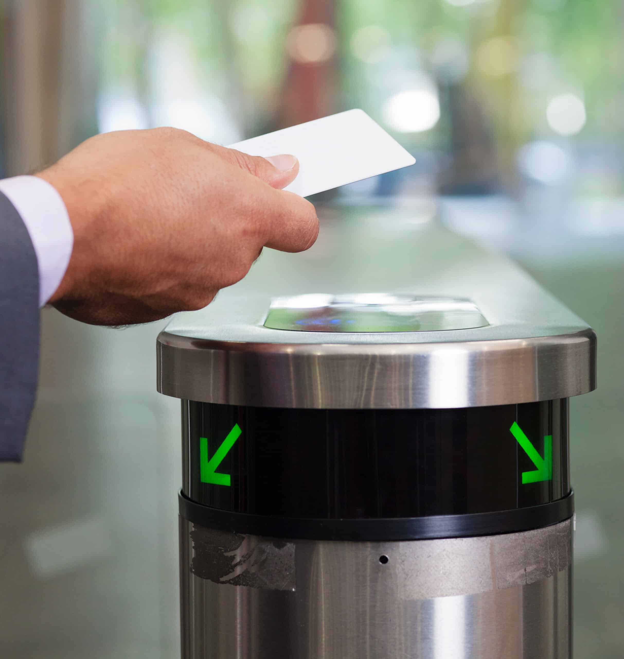 Mid adult businessmen swiping card through security gate