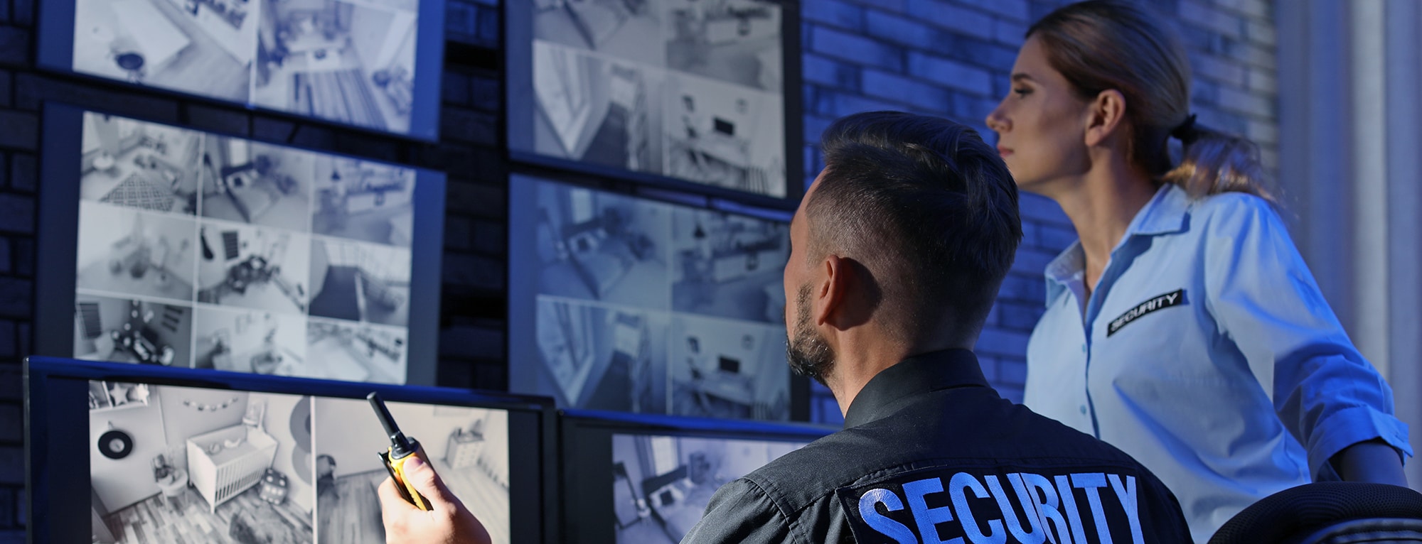 Security guards monitoring modern CCTV cameras indoors